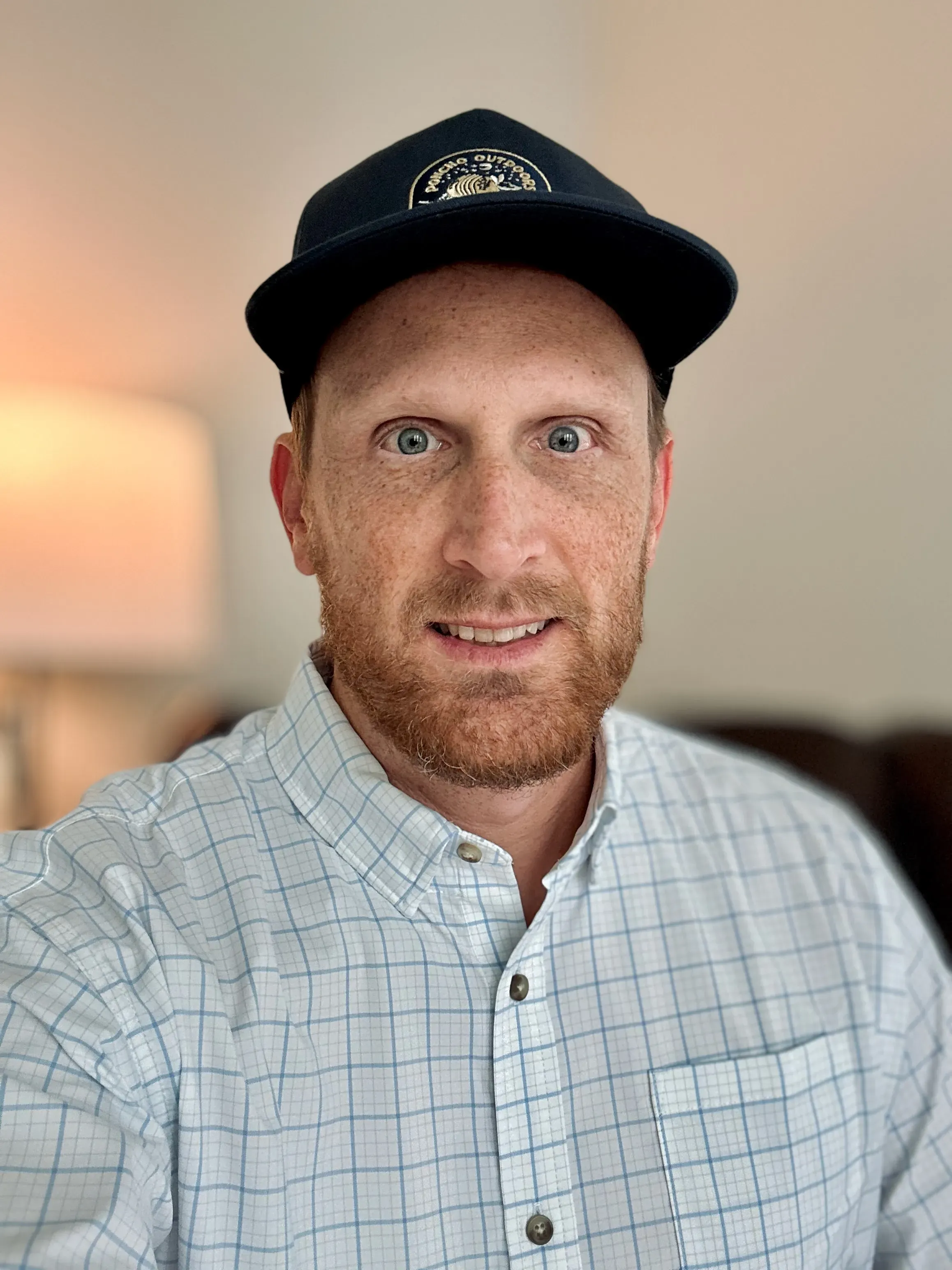 Casey Lewis, founder of CL Creative, in a navy cap and a blue checked button-down shirt