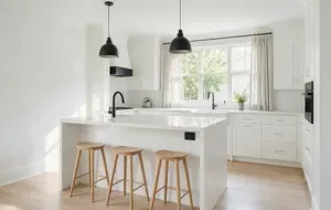 A finished kitchen remodel with a large island and pendant lights