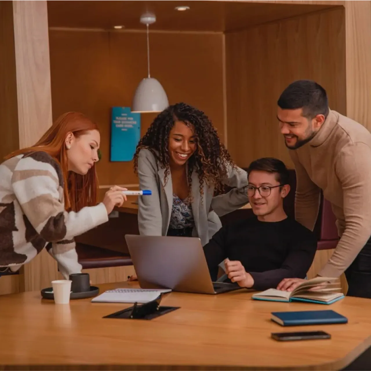 Team collaborating around a laptop