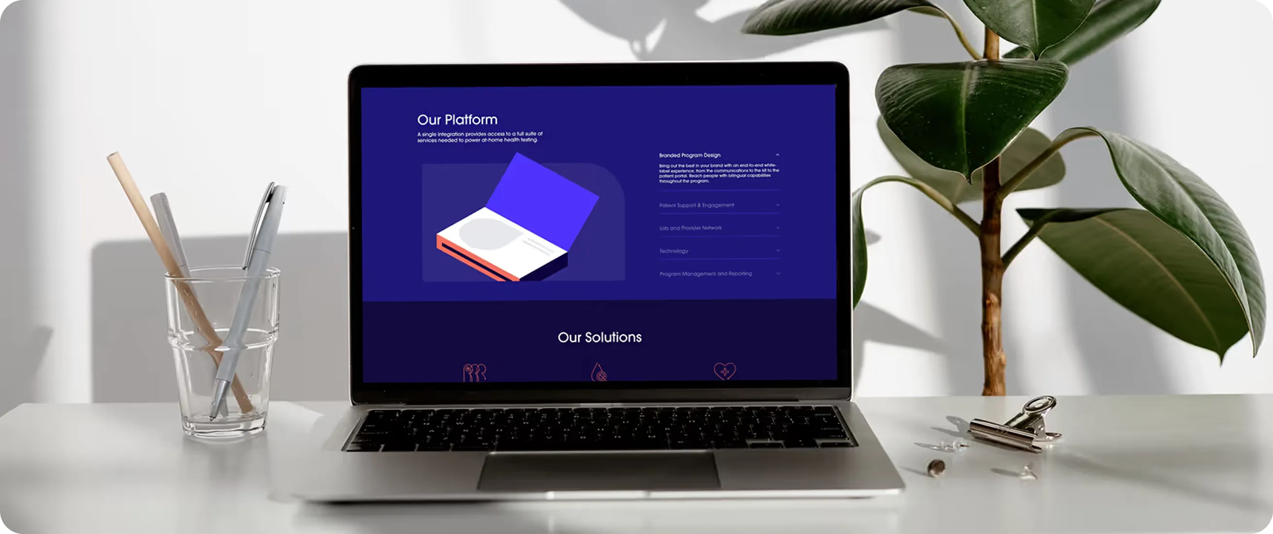 Laptop showing a Webflow website on a desk with plants